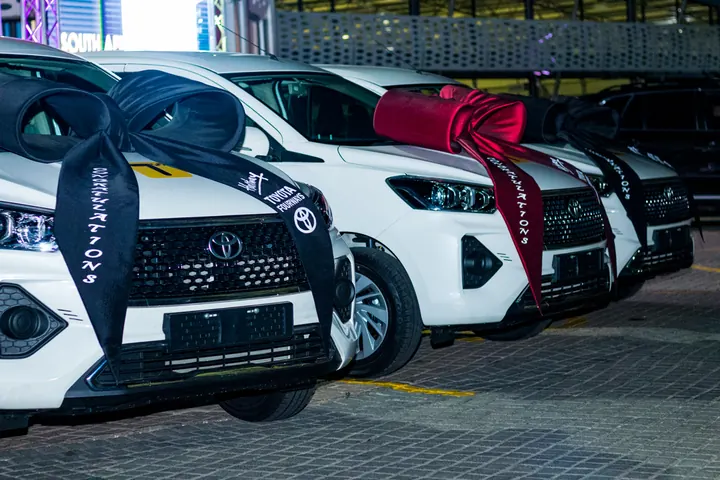 White Toyota fleet cars with handover ribbons at the launch