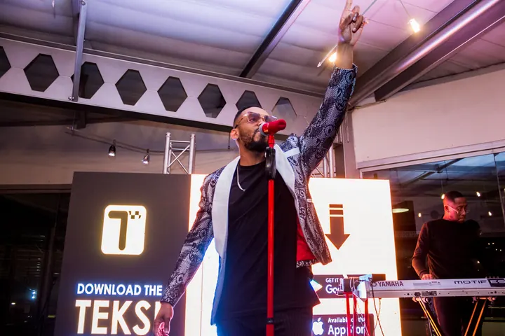 On stage in front of a Download the Teksi screen
