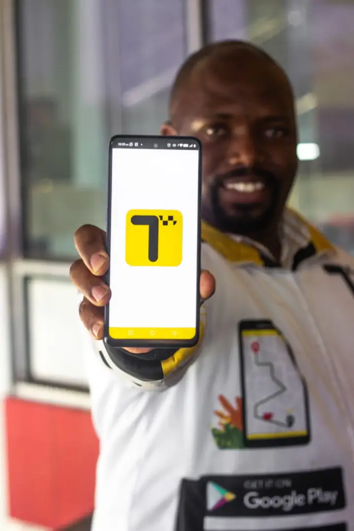 A Teksi Ride team member holding the app